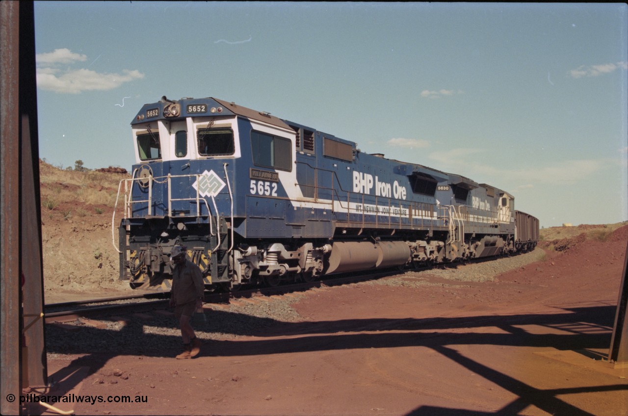 235-00
Yandi Two, BHP Iron Ore Goninan rebuild CM40-8M GE unit 5652 'Villanueva' serial 8412-09 / 93-143 arrives with the afternoon 240 waggon empty train with second unit Goninan built CM39-8 unit 5630 'Zeus', notice the fuel tank differences between the lead unit an ALCo rebuild and the second unit built new. The loadout operator is walking past the train.
Keywords: 5652;Goninan;GE;CM40-8M;8412-09/93-143;rebuild;AE-Goodwin;ALCo;M636C;5482;G6061-3;