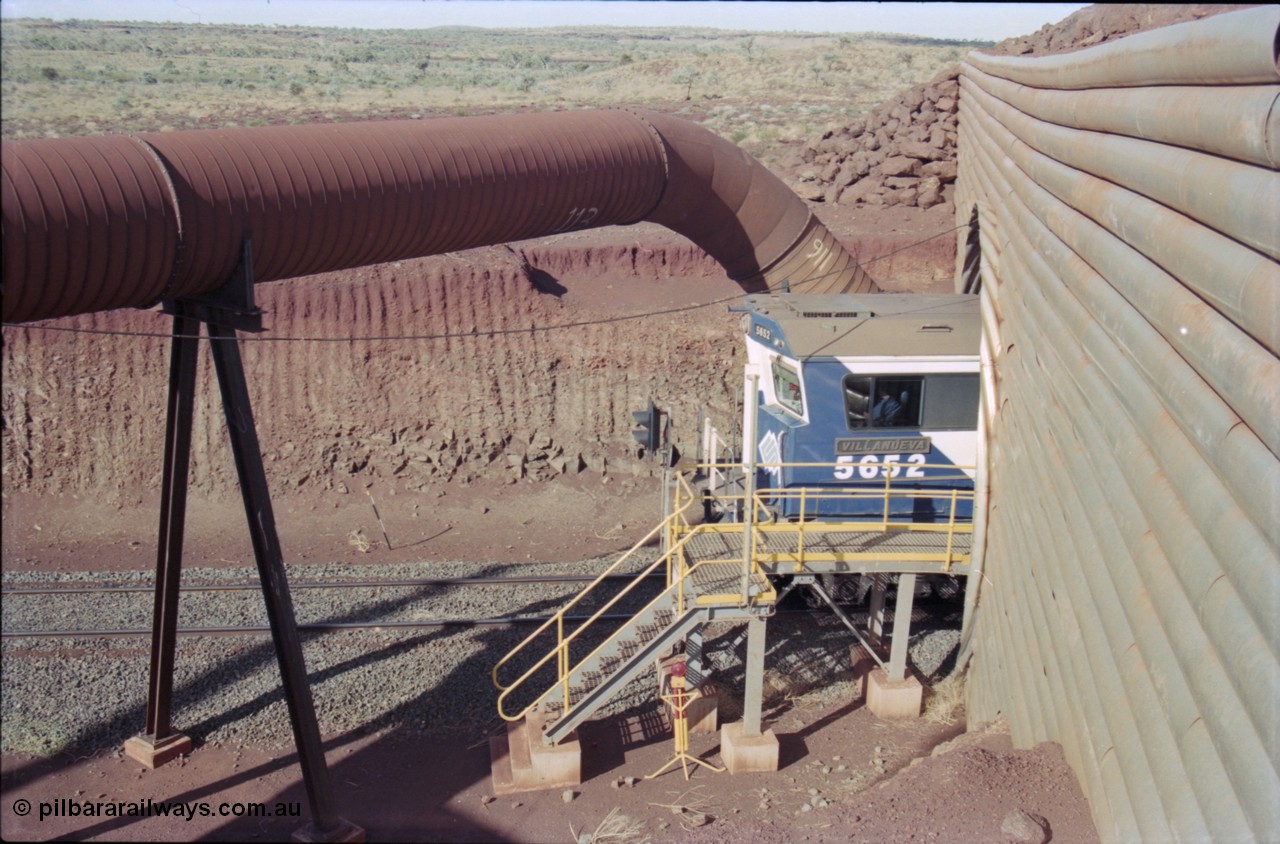 235-12
Yandi Two, BHP Iron Ore Goninan rebuild CM40-8M GE unit 5652 'Villanueva' serial 8412-09 / 93-143 passes out the other side of the loadout tunnel as loading has commenced, the dust extraction equipment and retaining wall culvert frame the loco.
Keywords: 5652;Goninan;GE;CM40-8M;8412-09/93-143;rebuild;AE-Goodwin;ALCo;M636C;5482;G6061-3;