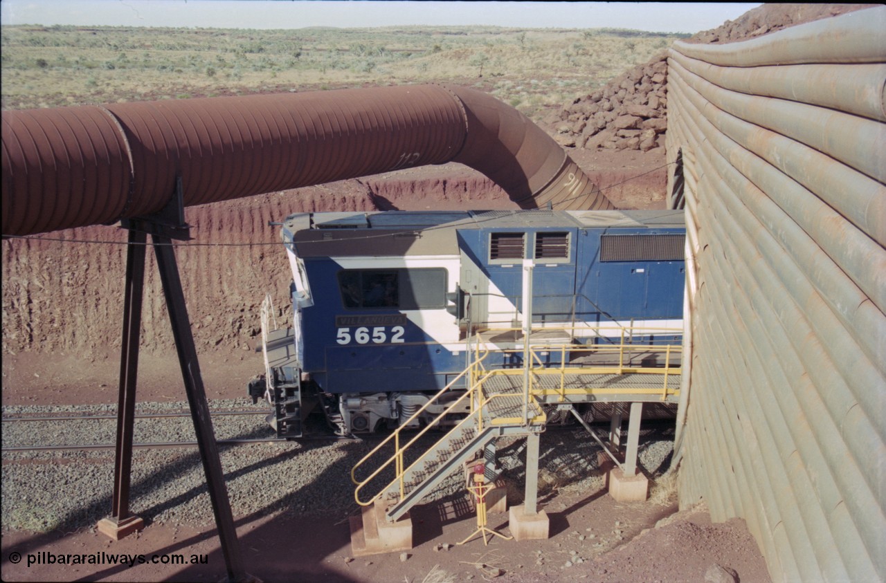 235-13
Yandi Two, BHP Iron Ore Goninan rebuild CM40-8M GE unit 5652 'Villanueva' serial 8412-09 / 93-143 passes out the other side of the loadout tunnel as loading has commenced, the dust extraction equipment and retaining wall culvert frame the loco.
Keywords: 5652;Goninan;GE;CM40-8M;8412-09/93-143;rebuild;AE-Goodwin;ALCo;M636C;5482;G6061-3;