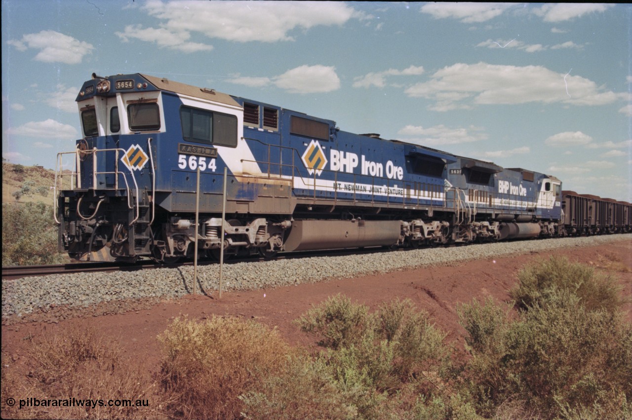 235-18
Yandi One, BHP Iron Ore Goninan rebuild CM40-8M GE unit 5654 'Kashima' serial 8412-11 / 93-145 sits on a loaded train awaiting departure time with second unit also a Goninan GE rebuild 5639 'Corunna Downs' serial 8281-03 / 92-128, note the differences in the two locos as 5653 is rebuilt from a Comeng built ALCo M636 while 5639 was an AE Goodwin built ALCo C636. 5654 also has the late marigold style BHP logo.
Keywords: 5654;Goninan;GE;CM40-8M;8412-11/93-145;rebuild;Comeng-NSW;ALCo;M636C;5493;C6084-9;