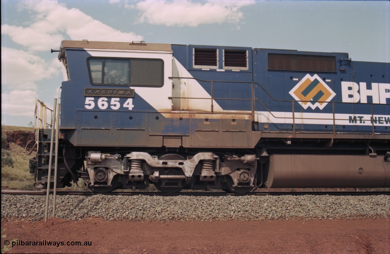 235-28
Yandi One, BHP Iron Ore Goninan rebuild CM40-8M GE unit 5654 'Kashima' serial 8412-11 / 93-145 sits on a loaded train awaiting departure time and also has the late marigold style BHP logo, cab side and Alco Hi-Ad bogie.
Keywords: 5654;Goninan;GE;CM40-8M;8412-11/93-145;rebuild;Comeng-NSW;ALCo;M636C;5493;C6084-9;