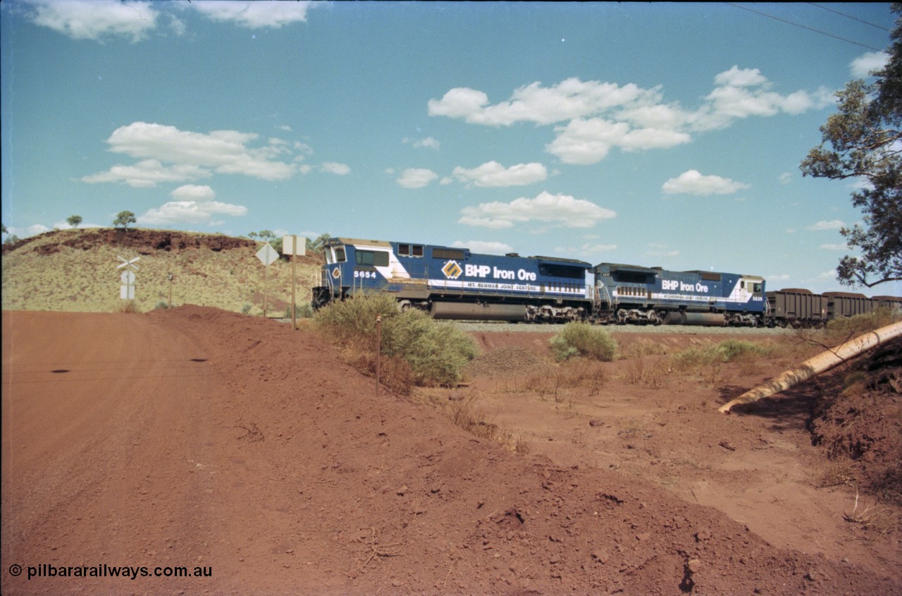 235-36
Yandi One, BHP Iron Ore Goninan rebuild CM40-8M GE unit 5654 'Kashima' serial 8412-11 / 93-145 sits on a loaded train awaiting departure time with second unit also a Goninan GE rebuild 5639 'Corunna Downs' serial 8281-03 / 92-128, note the differences in the two locos as 5653 is rebuilt from a Comeng built ALCo M636 while 5639 was an AE Goodwin built ALCo C636. 5654 also has the late marigold style BHP logo.
Keywords: 5654;Goninan;GE;CM40-8M;8412-11/93-145;rebuild;Comeng-NSW;ALCo;M636C;5493;C6084-9;