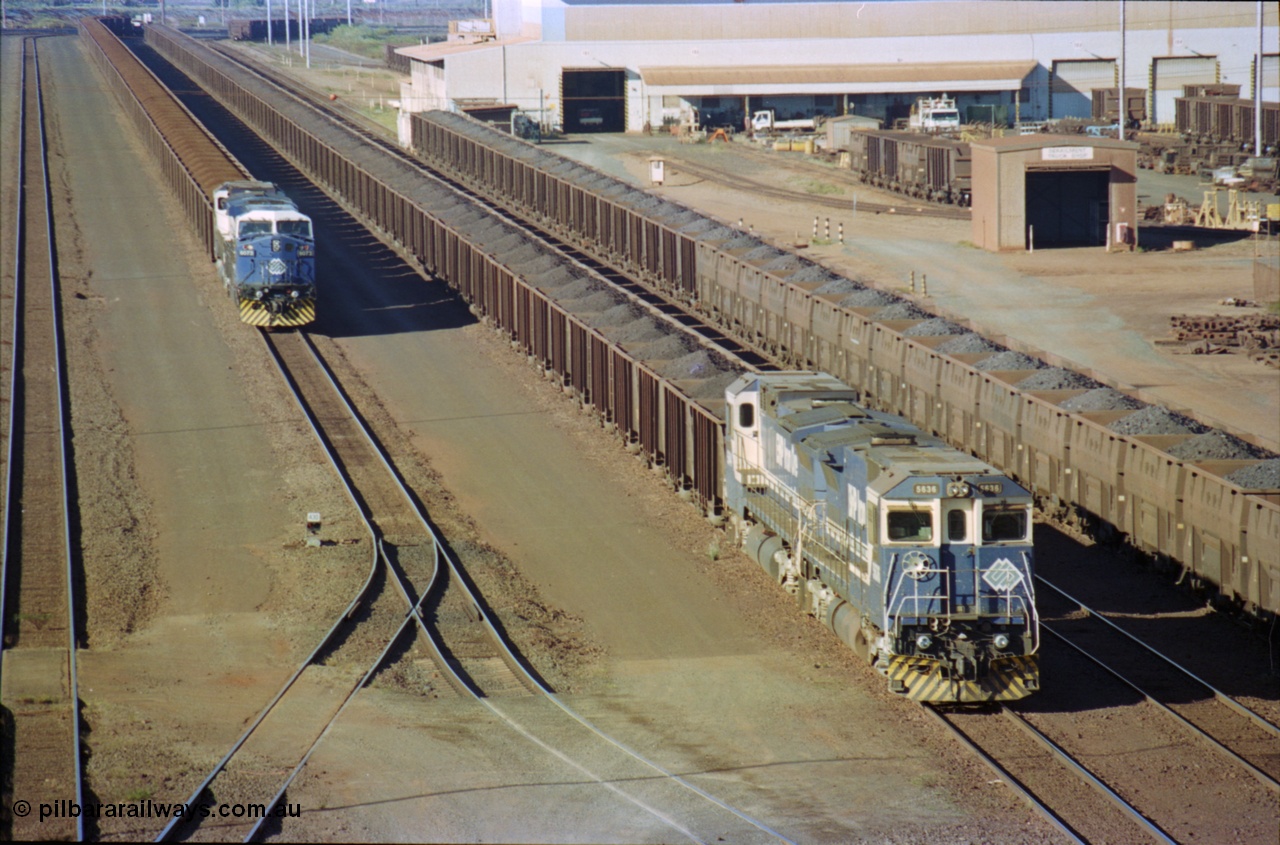 236-12
Nelson Point, Car Dumper Two delivery roads, BHP Dash 8 class locomotive 5636 'Munda', a Goninan 1991 rebuild to GE CM40-8M model, serial 8151-11 / 91-122 with a sister unit await to dump their train of Comeng style waggons, next to them is a string of Golynx style waggons and on the left sits an AC6000 6073 with a Dash 8 awaiting access to Car Dumper Three. The Ore Car Repair Shop is on the right.
Keywords: 5636;Goninan;GE;CM40-8M;8151-11/91-122;rebuild;AE-Goodwin;ALCo;C636;5462;G6035-3;