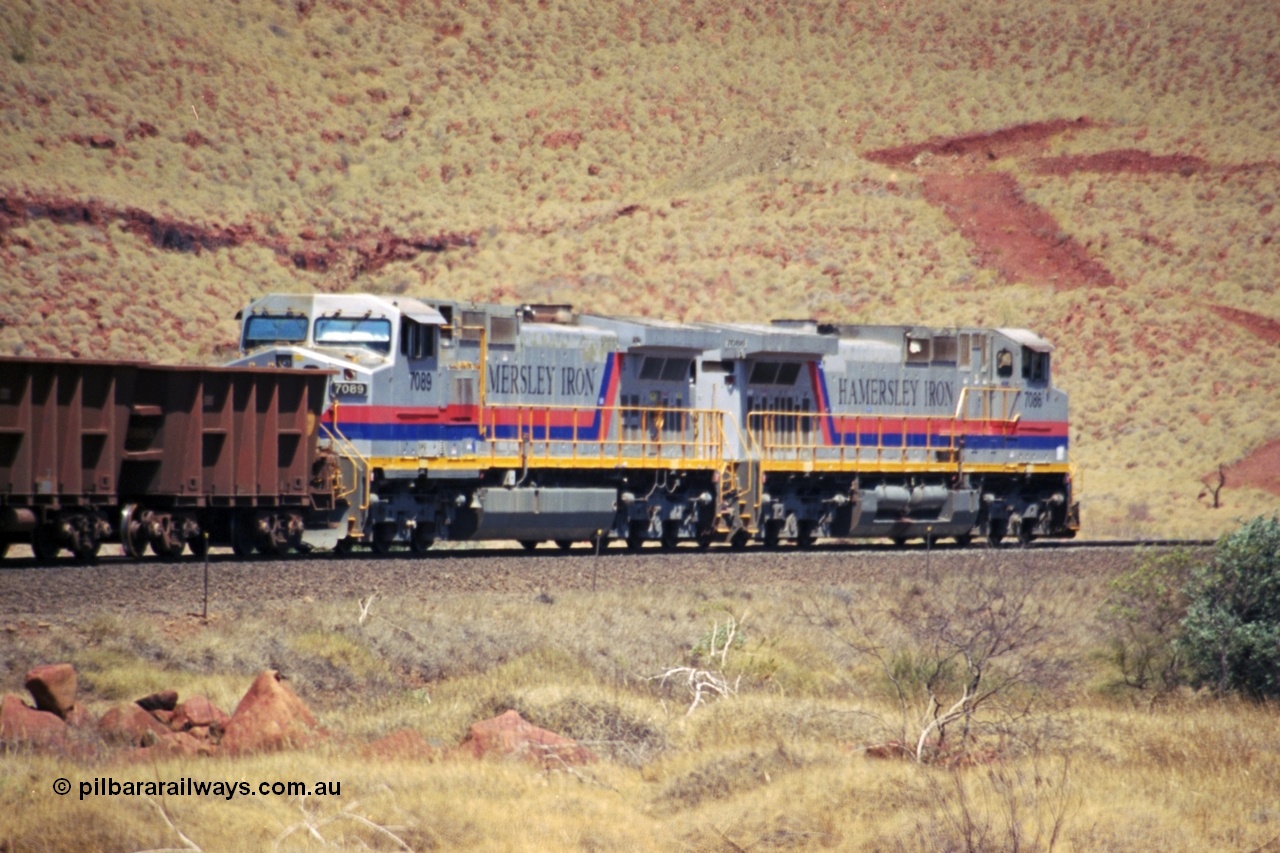 237-31
At the 89 km grade crossing on the Hamersley Iron mainline near Galah Siding, General Electric Dash 9-44CW units 7086 serial 47765 leads 7089 serial 47768 as they struggle up the grade with empty train.
