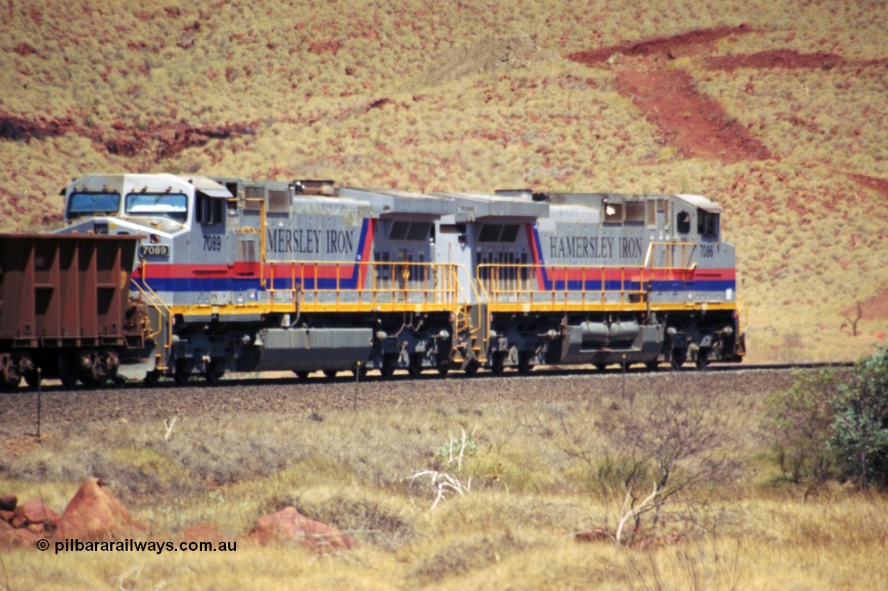 237-32
At the 89 km grade crossing on the Hamersley Iron mainline near Galah Siding, General Electric Dash 9-44CW units 7086 serial 47765 leads 7089 serial 47768 as they struggle up the grade with empty train.
