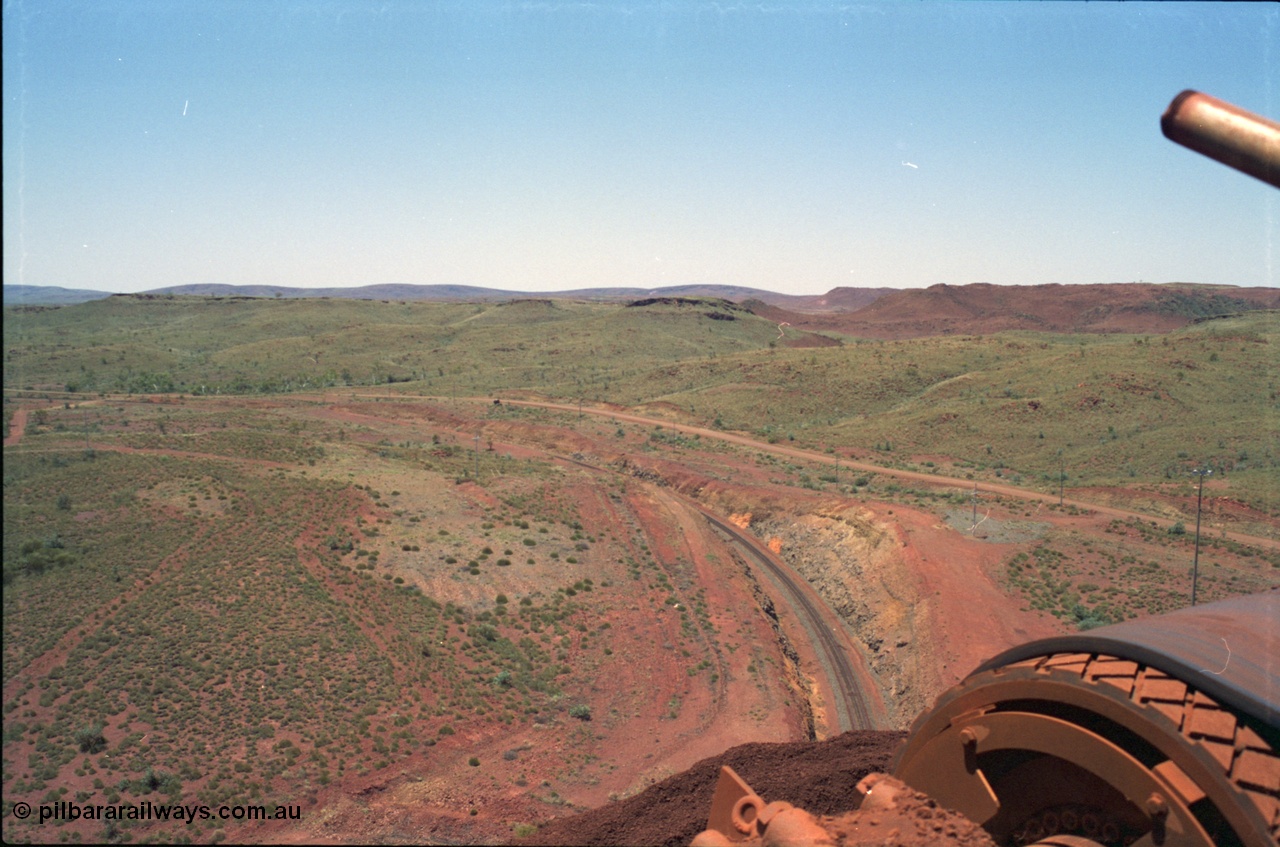 239-07
View from the Yandi One radial stacker looking north east, the camp for the mine is located a couple of kilometres beyond those front hills. The head drum of the conveyor and the ore stockpile are visible in the corner. [url=https://goo.gl/maps/hApNXoLtbtQ2]GeoData[/url].
