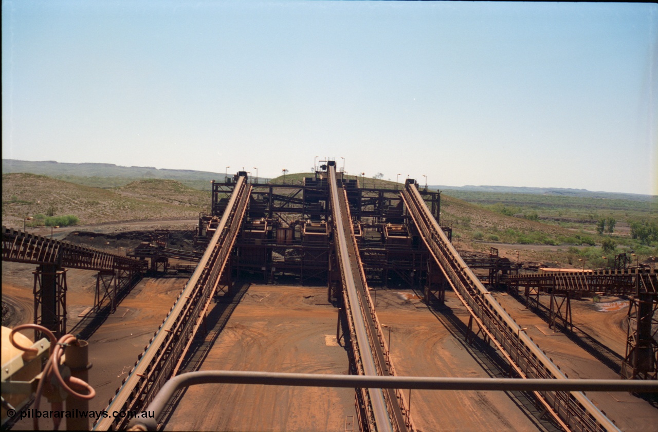 239-13
Overview of the Yandi One sizing plant looking north from above the middling crushers along CV4 (middle belt) to the screen house which houses six Jaques 'banana screens'. The feed bin and associated feed conveyors, travelling left and right can be clearly seen. The 'new side' is on the left and the 'old side' on the right. The feed along CV10 to the stockpile is obscured by the 'old side' structure and Sub-Station 3 can just be made out. [url=https://goo.gl/maps/2oJ3zTdoX1p]GeoData[/url].
