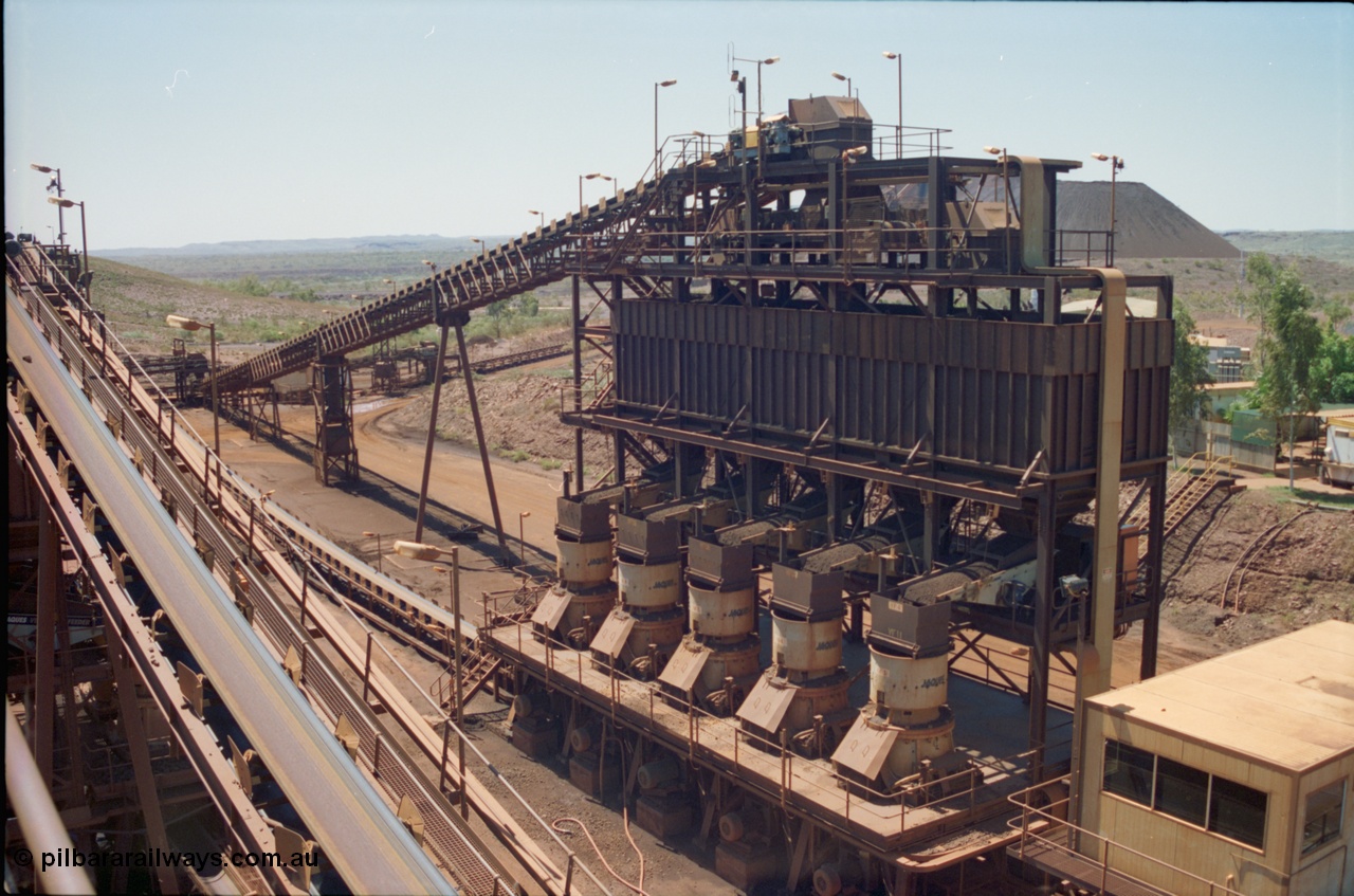 239-18
View of Yandi One OHP looking from the secondary crusher north east at the 'old side' bank of five tertiary crushers. The control room is in the bottom right corner and glimpses of the stockpile and power station and offices can be seen on the right. CV6 is running up the left of the image to the middling crushers. [url=https://goo.gl/maps/gpgfApaAJYt]GeoData[/url].
