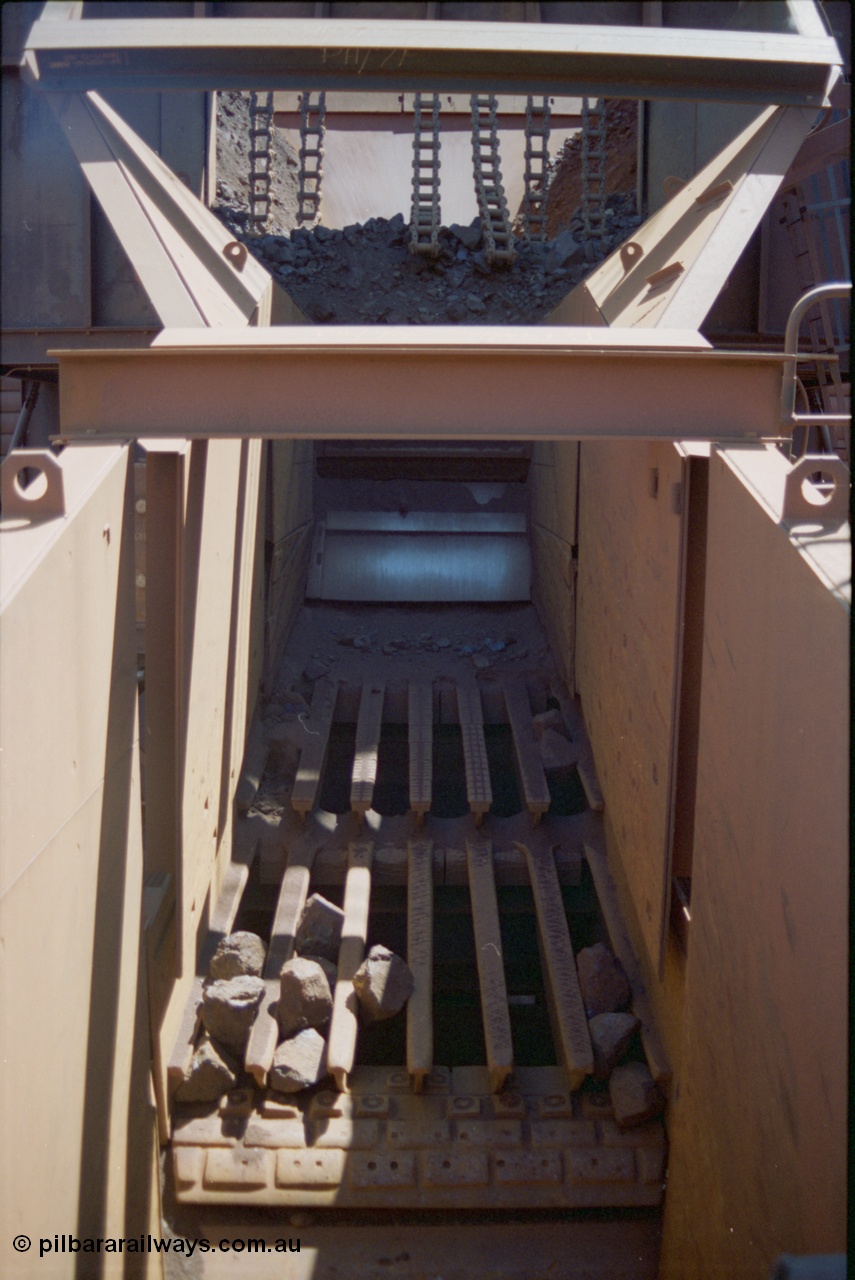 239-20
Yandi One primary crusher, GS01, a Jaques grizzly screen 01 with the ROM (run of mine) or raw material bin above it. The dozer track chain links are to prevent surges of material spilling out of the bin uncontrolled and flooding the screen and jaw crusher. Any small material will fall between the grizzly bars and bypass the Jaques single-toggle jaw crusher. [url=https://goo.gl/maps/sqRX6geV26p]GeoData[/url].
