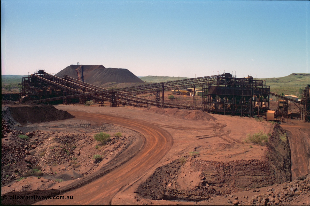 239-22
Overview of Yandi One OHP plant as viewed from the head end of CV2 conveyor which runs from the primary crusher to the reclaim pile. Visible from the left is the screen house, radial stacker on the stockpile, power station, new and old side tertiary crushing structures, sub-station 4, the control room and on the extreme right the secondary crusher structure. [url=https://goo.gl/maps/EyA7dYyg3yK2]GeoData[/url].
