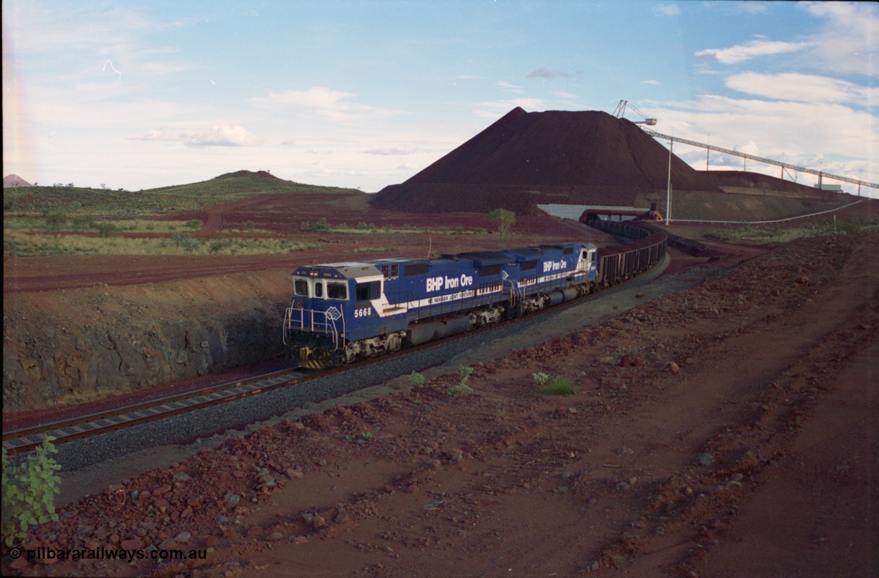 239-34
Yandi Two, train loading is under way with a pair of Goninan rebuild units, CM40-8MEFI unit 5668 'Dunkirk' serial 8412-01/95-159 and CM40-8M unit 5644 'Kangan' serial 8281-09/92-133. The lead unit was originally Comeng NSW built ALCo M636 5489 serial C6084-5, while second unit 5644 was originally a AE Goodwin built ALCo M636 5471 serial G6047-3.
