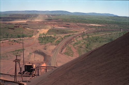 239-05
View from the radial stacker boom at Yandi One looking west, the rail loading balloon loop and dust extractor are visible at the bottom of the image and the mine waste dump is in the background. [url=https://goo.gl/maps/hApNXoLtbtQ2]GeoData[/url].
