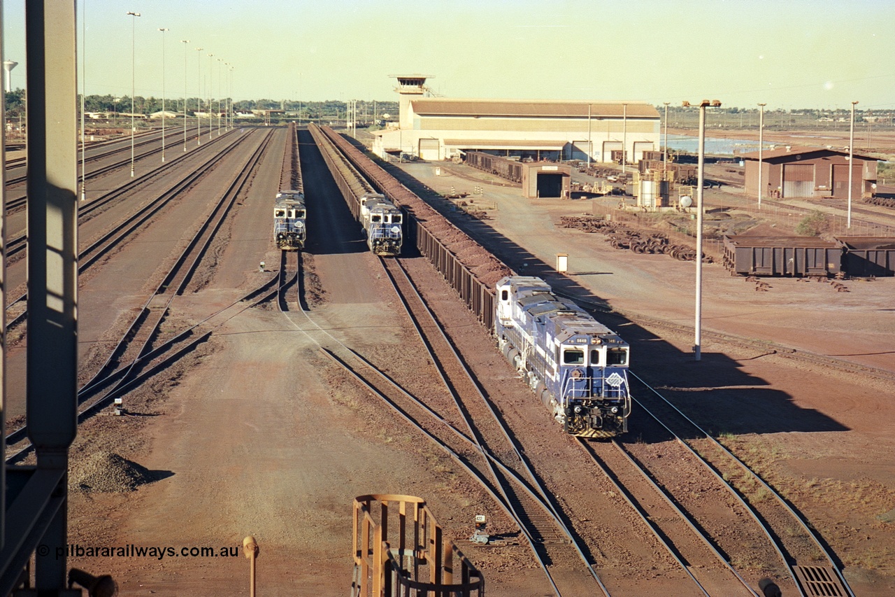 241-28
Nelson Point, Car Dumper 2 holding roads with Yard Control tower and Ore Car Repair Shop in the background as three loaded ore rakes behind a pair of CM40-8M units on each wait their turn through the dumper to discharge. June 2002.
