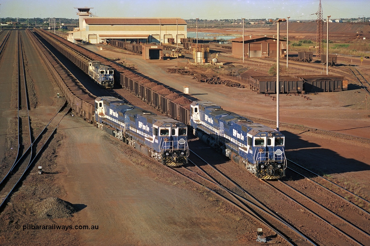 241-36
Nelson Point, Car Dumper 2 holding roads with Yard Control tower and Ore Car Repair Shop in the background as two loaded ore rakes behind pairs of CM40-8M units on each wait their turn through the dumper to discharge as 5660 'Kure' serial 8412-05 / 94-151 and 5657 'Fukuyama' drag their loaded train towards the dumper to discharge . June 2002.
Keywords: 5660;Goninan;GE;CM40-8M;8412-05/94-151;rebuild;AE-Goodwin;ALCo;M636C;5478;G6047-10;