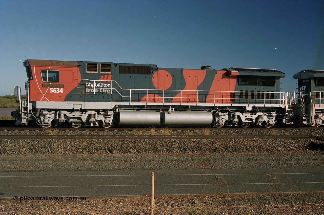 243-21
Nelson Point departure yard, BHP Billiton's CM40-8M unit 5634 'Boodarie' a Goninan WA GE rebuild unit serial 8151-07 / 91-120 in the new 'earth' or 'bubble' livery as it heads up an empty train waiting departure time. August 2003.
Keywords: 5634;Goninan;GE;CM40-8M;8151-07/91-120;rebuild;AE-Goodwin;ALCo;C636;5457;G6027-1;