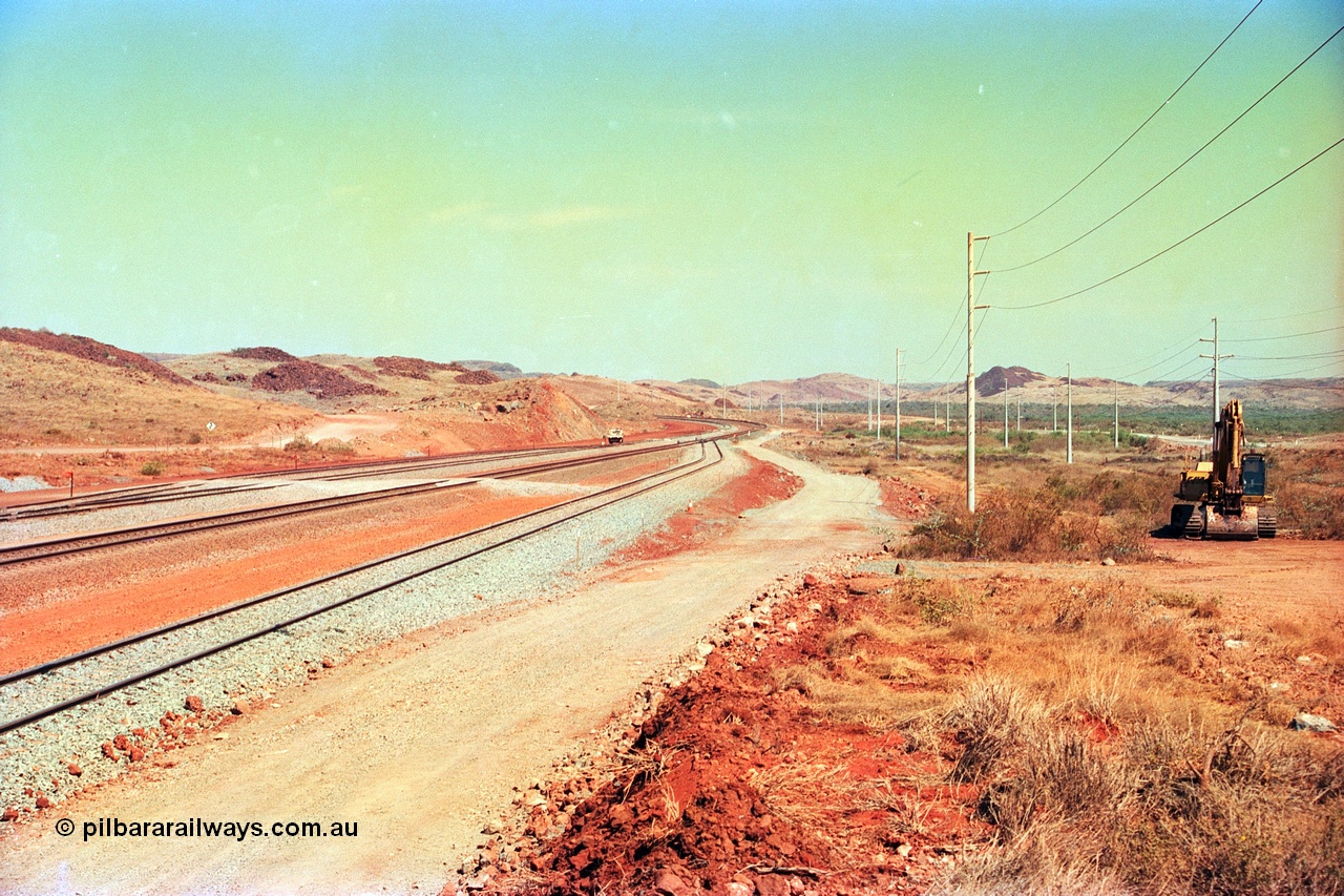 246-01
Cape Lambert, yard view of the then new extension to the south for the West Angelas mine was coming on stream, the siding on the far left will become a compressor waggon holding road, the 6 km and Boat Beach Rd grade crossing are around the corner to the left. The original line or Mainline is the second from the camera, with the car dumper one Empty Car line closest, and what becomes the car dumper two Loaded Car line is third. 22nd May 2002.
