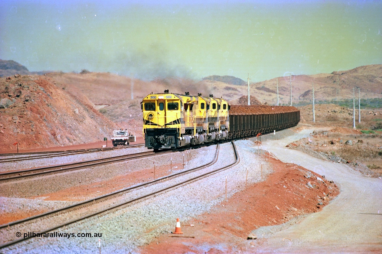 246-14
Cape Lambert, yard view of the then new extension to the south for the West Angelas mine was coming on stream as a Robe River loaded Deepdale train arrives on the main behind the standard quad Dash 8 power with 202 waggons. 9414 which is a Goninan WA ALCo to GE rebuild CM40-8M with serial 8206-11 / 91-124 from November 1991 and was originally an AE Goodwin built M636 ALCo built new for Robe in December 1971 and numbered 262.005, later numbered 1714. 22nd May 2002.
Keywords: 9414;Goninan;GE;CM40-8M;8206-11/91-124;rebuild;AE-Goodwin;ALCo;M636;G6060-5;