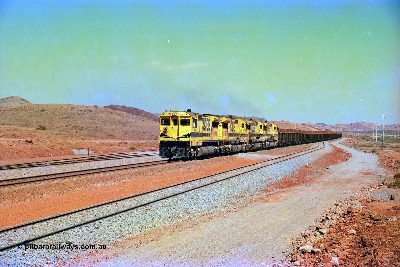 246-17
Cape Lambert, yard view of the then new extension to the south for the West Angelas mine was coming on stream as a Robe River loaded Deepdale train arrives on the main behind the standard quad Dash 8 power with 202 waggons. 9414 which is a Goninan WA ALCo to GE rebuild CM40-8M with serial 8206-11 / 91-124 from November 1991 and was originally an AE Goodwin built M636 ALCo built new for Robe in December 1971 and numbered 262.005, later numbered 1714. 22nd May 2002.
Keywords: 9414;Goninan;GE;CM40-8M;8206-11/91-124;rebuild;AE-Goodwin;ALCo;M636;G6060-5;