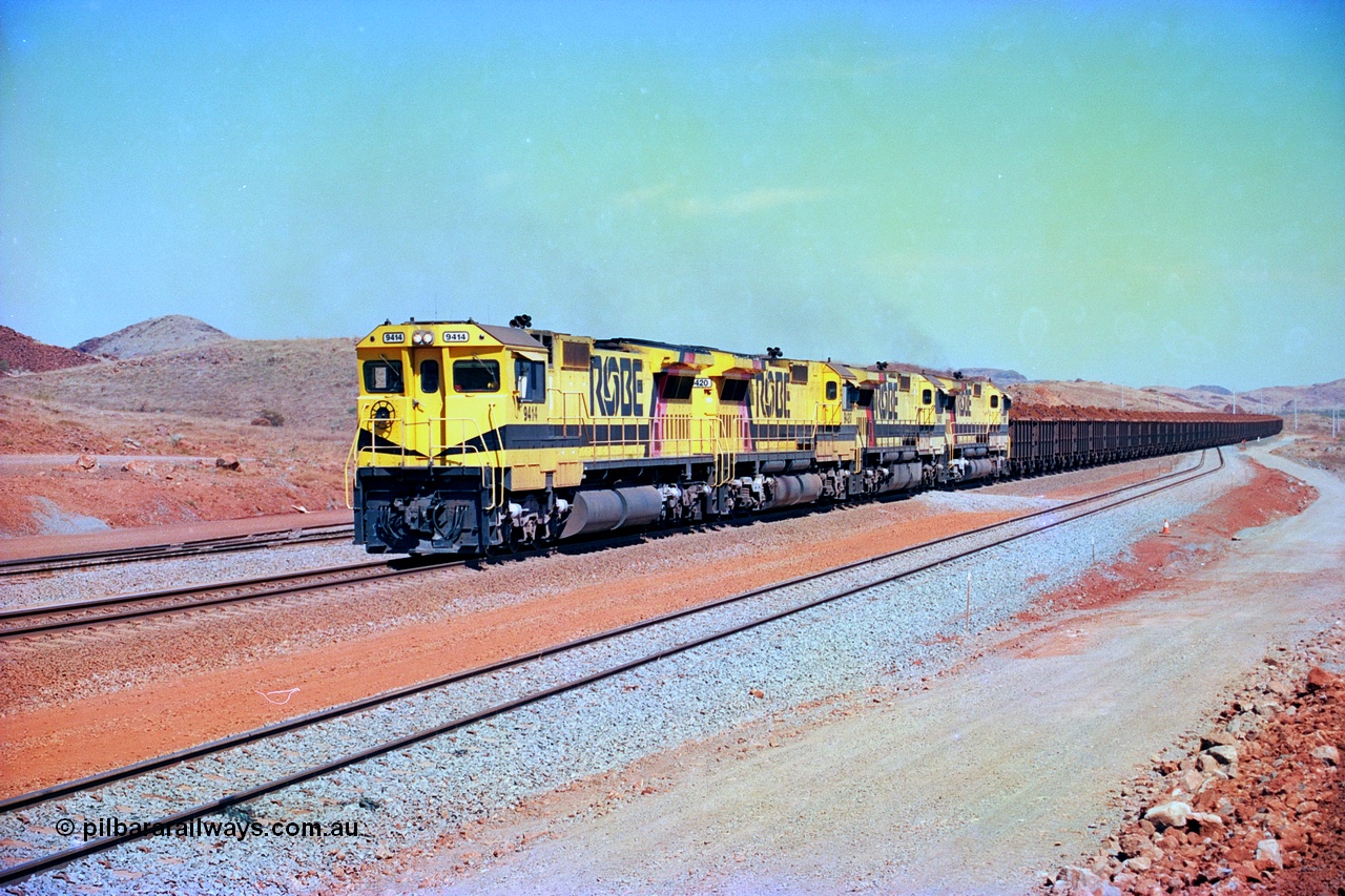 246-18
Cape Lambert, yard view of the then new extension to the south for the West Angelas mine was coming on stream as a Robe River loaded Deepdale train arrives on the main behind the standard quad Dash 8 power with 202 waggons. 9414 which is a Goninan WA ALCo to GE rebuild CM40-8M with serial 8206-11 / 91-124 from November 1991 and was originally an AE Goodwin built M636 ALCo built new for Robe in December 1971 and numbered 262.005, later numbered 1714. 22nd May 2002.
Keywords: 9414;Goninan;GE;CM40-8M;8206-11/91-124;rebuild;AE-Goodwin;ALCo;M636;G6060-5;