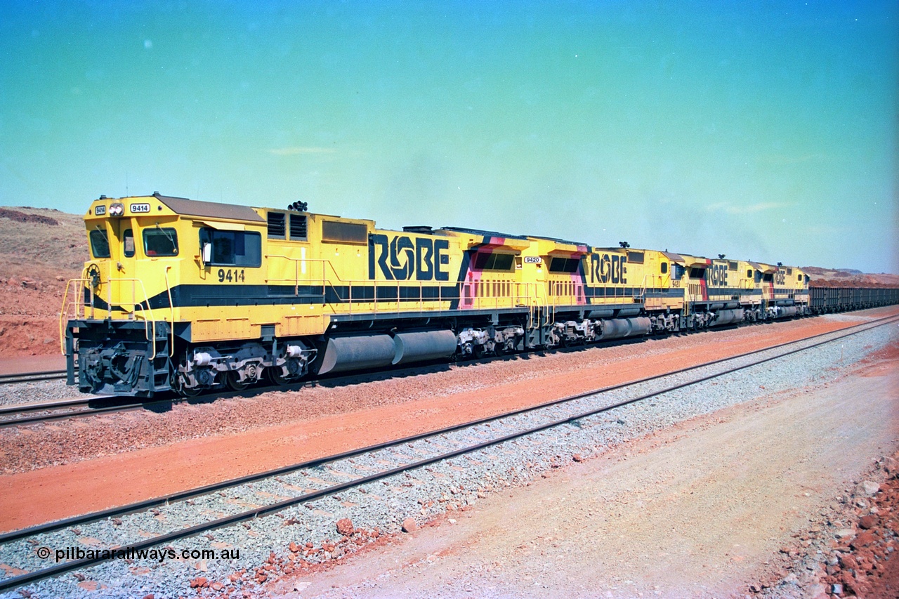 246-21
Cape Lambert, a Robe River loaded Deepdale train arrives on the main behind the standard quad Dash 8 power with 202 waggons. 9414 which is a Goninan WA ALCo to GE rebuild CM40-8M with serial 8206-11 / 91-124 from November 1991 riding on Dofasco bogies and was originally an AE Goodwin built M636 ALCo built new for Robe in December 1971 and numbered 262.005, later numbered 1714. 22nd May 2002.
Keywords: 9414;Goninan;GE;CM40-8M;8206-11/91-124;rebuild;AE-Goodwin;ALCo;M636;G6060-5;