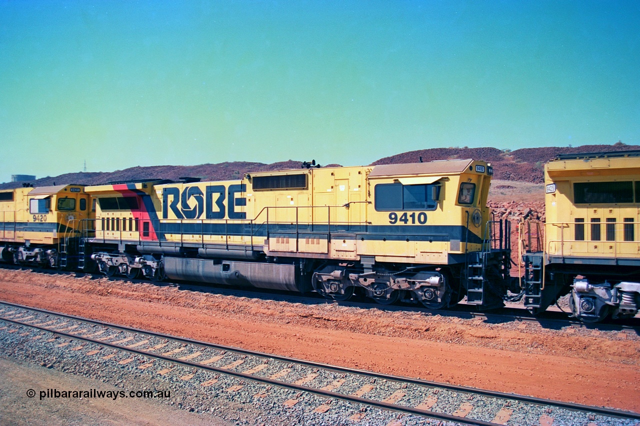 246-24
Cape Lambert, Robe River locomotive 9410 which is a Goninan WA ALCo to GE rebuild CM40-8M with serial 2160-03 / 96-202 from March 1996 riding on Dofasco bogies and was originally a Comeng NSW built M636 ALCo serial C-6096-5 and built new for Mt Newman Mining (later BHP Iron Ore) in November 1975 and numbered 5500. Everything below the frame is ALCo, with the Comeng style flat fuel tank, while above is GE and Pilbara Cab. 22nd May 2002.
Keywords: 9410;Goninan;GE;CM40-8M;2160-03/96-202;rebuild;Comeng-NSW;ALCo;M636;C-6096-5;