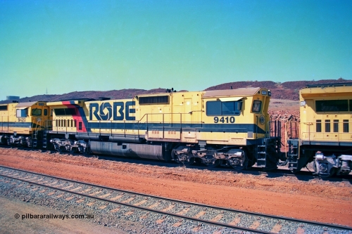 246-24
Cape Lambert, Robe River locomotive 9410 which is a Goninan WA ALCo to GE rebuild CM40-8M with serial 2160-03 / 96-202 from March 1996 riding on Dofasco bogies and was originally a Comeng NSW built M636 ALCo serial C-6096-5 and built new for Mt Newman Mining (later BHP Iron Ore) in November 1975 and numbered 5500. Everything below the frame is ALCo, with the Comeng style flat fuel tank, while above is GE and Pilbara Cab. 22nd May 2002.
Keywords: 9410;Goninan;GE;CM40-8M;2160-03/96-202;rebuild;Comeng-NSW;ALCo;M636;C-6096-5;