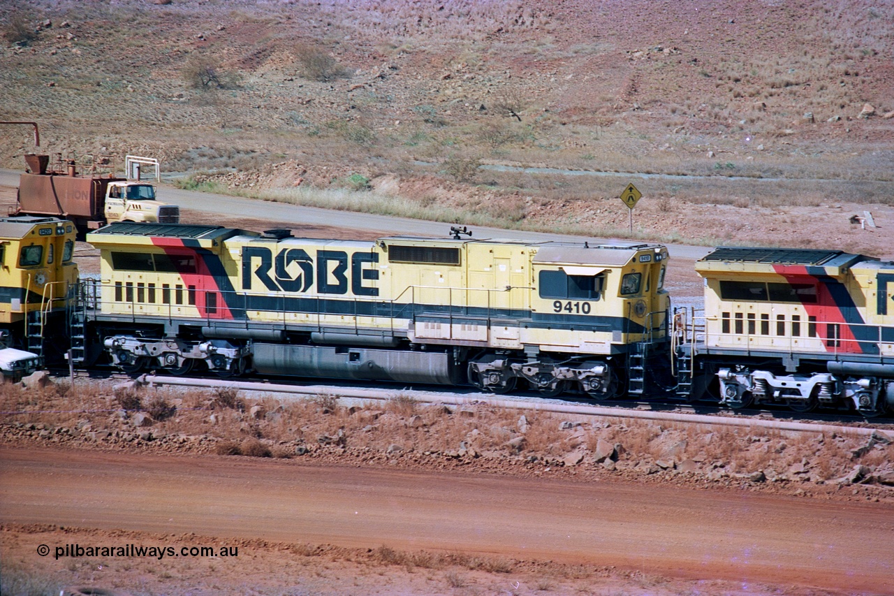 247-06
Cape Lambert fuel point, Robe River locomotive 9410 which is a Goninan WA ALCo to GE rebuild CM40-8M with serial 2160-03 / 96-202 from March 1996 riding on Dofasco bogies and was originally a Comeng NSW built M636 ALCo serial C-6096-5 and built new for Mt Newman Mining (later BHP Iron Ore) in November 1975 and numbered 5500. Everything below the frame is ALCo, with the Comeng build style flat fuel tank, while above is GE and Pilbara Cab. Approximate location of the locos is [url=https://goo.gl/maps/DEynwwkV9PZra5Gm7]here[/url]. 22nd May 2002.
Keywords: 9410;Goninan;GE;CM40-8M;2160-03/96-202;rebuild;Comeng-NSW;ALCo;M636;C-6096-5;