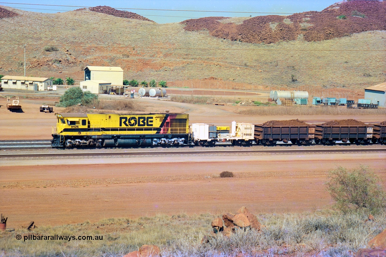 247-12
Cape Lambert, Robe River's 9426 a Comeng WA rebuild from ALCo Schenectady NY model C636 serial 3499-3 originally built in January 1968 for Pennsylvania as #6332, Penn Central 6332 and finally Conrail 6782. Purchased in 1986 and rebuilt by Comeng WA into C636R before delivery to Robe in November 1986. This loco also went on to become DR 8401 for construction of FMG's railway in 2007-08. Seen here in the South Yard dragging a loaded rake down to the car dumper. Approximate location of train is [url=https://goo.gl/maps/L8Y75jkpyVdps6pg6]here[/url]. 22nd May 2002.
Keywords: 9426;Comeng-WA;C636R;WA143-1;rebuild;ALCo;Schenectady-NY;C636;Conrail;6782;3499-3;