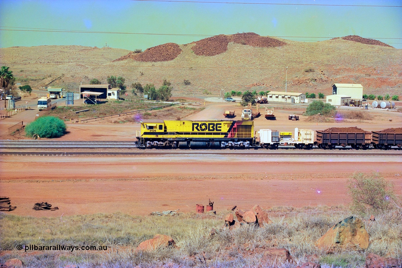 247-18
Cape Lambert, Robe River's 9426 a Comeng WA rebuild from ALCo Schenectady NY model C636 serial 3499-3 originally built in January 1968 for Pennsylvania as #6332, Penn Central 6332 and finally Conrail 6782. Purchased in 1986 and rebuilt by Comeng WA into C636R before delivery to Robe in November 1986. This loco also went on to become DR 8401 for construction of FMG's railway in 2007-08. Seen here dragging a loaded 101 waggon rake down to the car dumper from the South Yard at Bells Crossing. Approximate location of train is [url=https://goo.gl/maps/gFwTfdqvJ3c21N4u7]here[/url]. 22nd May 2002.
Keywords: 9426;Comeng-WA;C636R;WA143-1;rebuild;ALCo;Schenectady-NY;C636;Conrail;6782;3499-3;