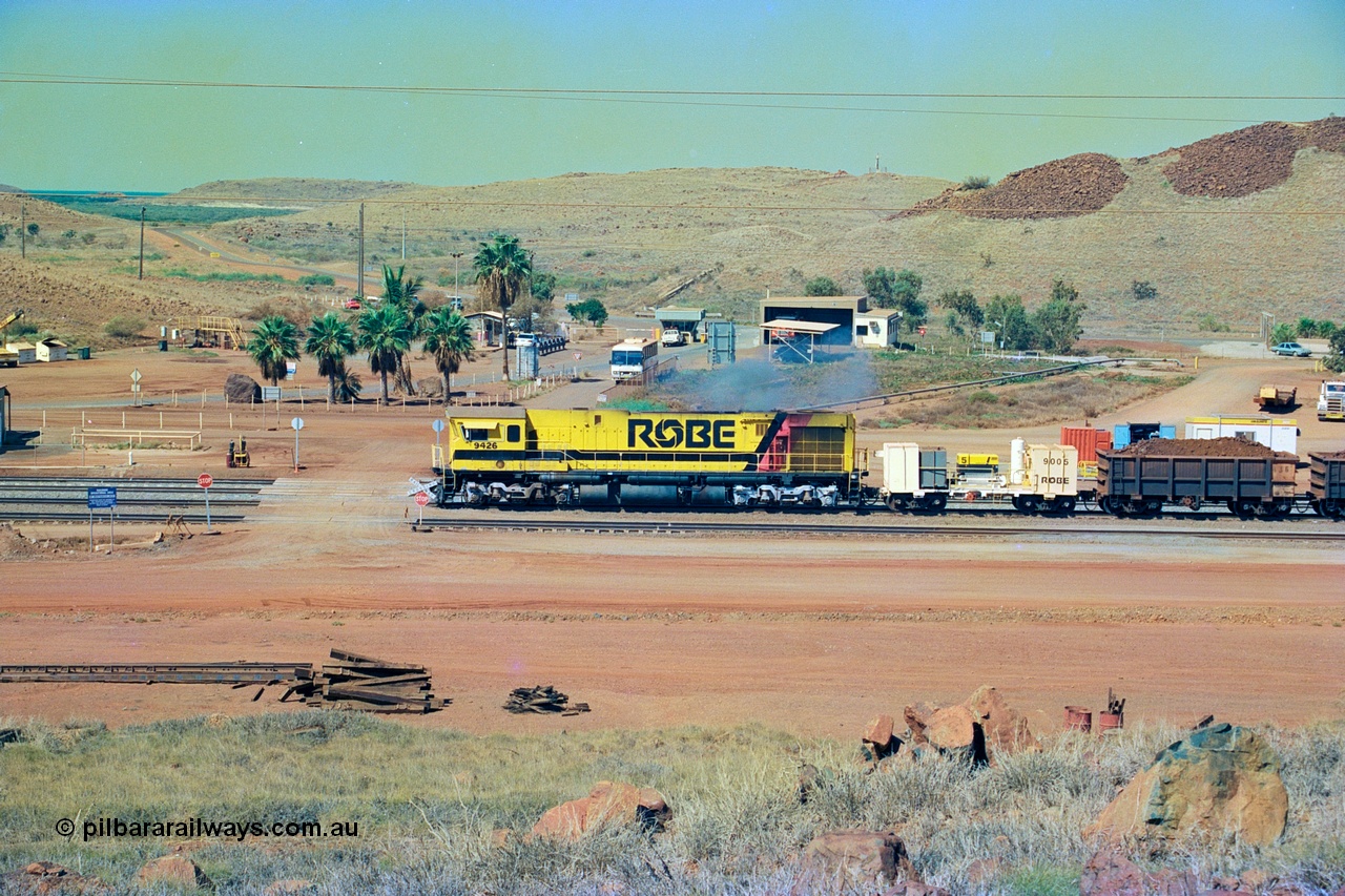 247-19
Cape Lambert, Robe River's 9426 a Comeng WA rebuild from ALCo Schenectady NY model C636 serial 3499-3 originally built in January 1968 for Pennsylvania as #6332, Penn Central 6332 and finally Conrail 6782. Purchased in 1986 and rebuilt by Comeng WA into C636R before delivery to Robe in November 1986. This loco also went on to become DR 8401 for construction of FMG's railway in 2007-08. Seen here dragging a loaded 101 waggon rake down to the car dumper at Bells Crossing. Approximate location of train is [url=https://goo.gl/maps/gFwTfdqvJ3c21N4u7]here[/url]. 22nd May 2002.
Keywords: 9426;Comeng-WA;C636R;WA143-1;rebuild;ALCo;Schenectady-NY;C636;Conrail;6782;3499-3;