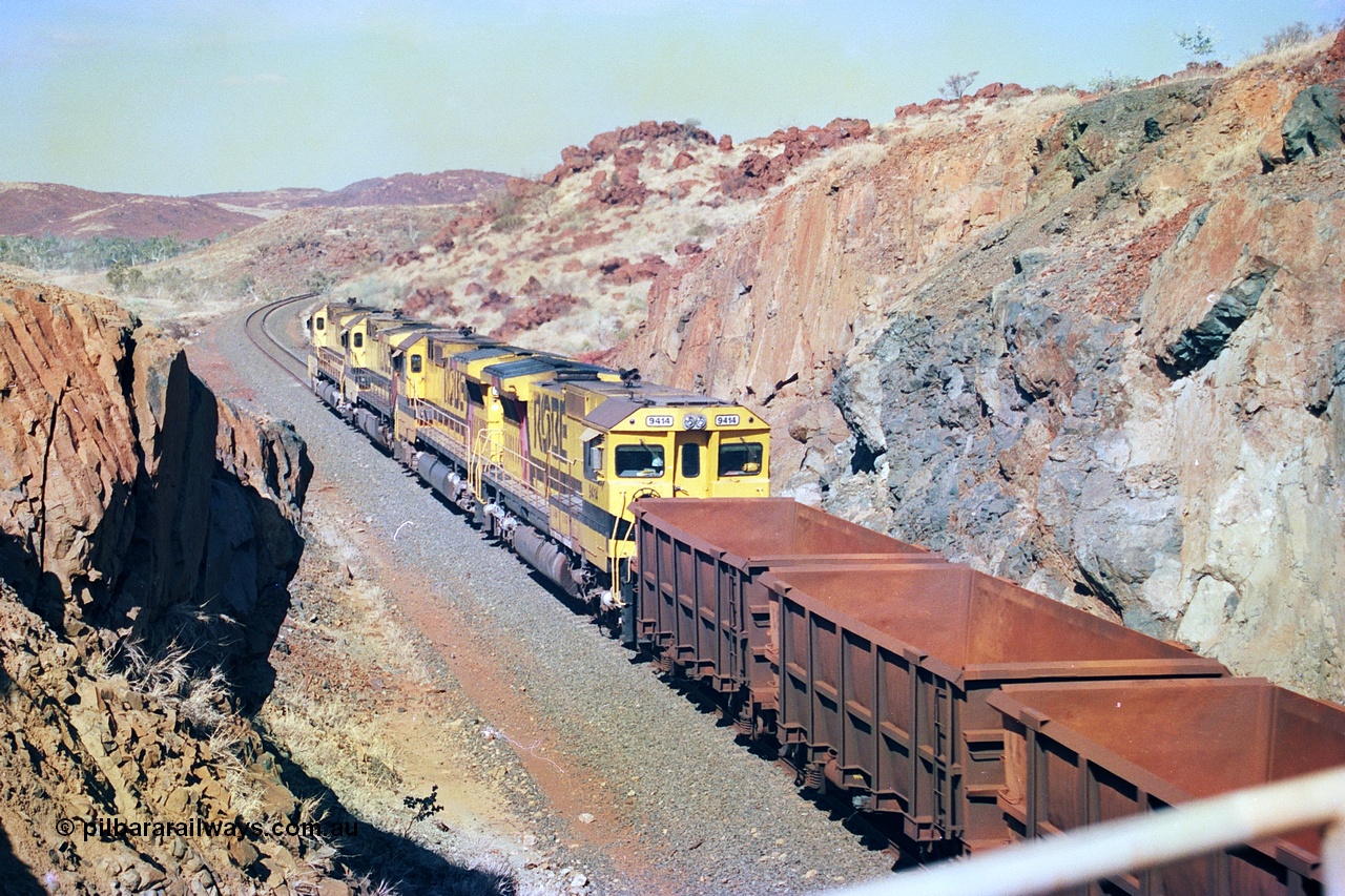 247-34
Near Cooya Pooya at the 37.5 km on the Robe River Cape Lambert line an empty train passes under the town water supply pipeline and pass through Lockyer Gap behind the standard Robe power of quad CM40-8M or Dash 8 locomotives led by 9425 with 9410, 9420 and last unit 9414 which is a Goninan WA ALCo to GE rebuild CM40-8M with serial 8206-11 / 91-124 from November 1991 riding on Dofasco bogies and was originally an AE Goodwin built M636 ALCo built new for Robe in December 1971 and numbered 262.005, later numbered 1714. Location is [url=https://goo.gl/maps/nLyndU6bg2HA5SZX6]here[/url].22nd May 2002.
Keywords: 9414;Goninan;GE;CM40-8M;8206-11/91-124;rebuild;AE-Goodwin;ALCo;M636;G6060-5;