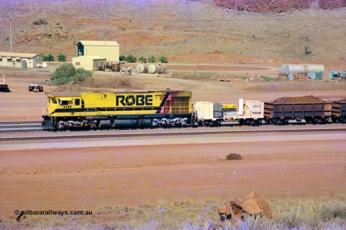 247-11
Cape Lambert, Robe River's 9426 a Comeng WA rebuild from ALCo Schenectady NY model C636 serial 3499-3 originally built in January 1968 for Pennsylvania as #6332, Penn Central 6332 and finally Conrail 6782. Purchased in 1986 and rebuilt by Comeng WA into C636R before delivery to Robe in November 1986. This loco also went on to become DR 8401 for construction of FMG's railway in 2007-08. Seen here in the South Yard dragging a loaded rake down to the car dumper. Approximate location of train is [url=https://goo.gl/maps/L8Y75jkpyVdps6pg6]here[/url]. 22nd May 2002.
Keywords: 9426;Comeng-WA;C636R;WA143-1;rebuild;ALCo;Schenectady-NY;C636;Conrail;6782;3499-3;