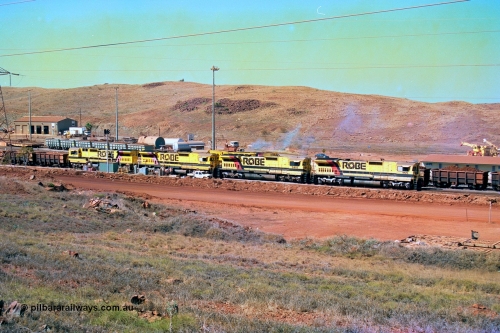 247-23
Cape Lambert overview of the fuel point, with a brace of four Goninan WA CM40-8M GE rebuilds finishing up refuelling before departing with another empty train as a loaded rake is dragged to the dumper behind them. The workshops are to the left of the picture. Where I'm standing to take the picture is now all stockpile. Approximate location of photo is [url=https://goo.gl/maps/B9F4estGGPbd2GrB6]here[/url]. 22nd May 2002.
