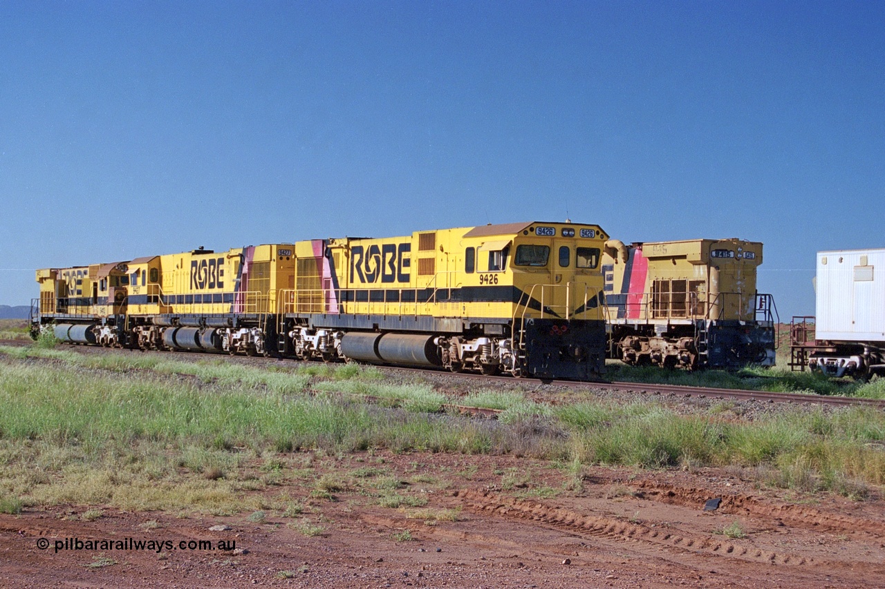 248-15
Seven Mile yard, stored Robe River ALCo locomotives at the south end of the Hamersley Iron Seven Mile yard on roads N2 and N3. On road N2 is 9426 a Comeng WA C636R rebuild from ALCo Schenectady NY model C636 serial 3499-3 originally built in January 1968 for Pennsylvania Railroad as #6332, Penn Central 6332 and finally Conrail 6782. Purchased in 1986 and rebuilt by Comeng WA into C636R before delivery to Robe in November 1986. This loco also went on to become DR 8401 for construction of FMG's railway in 2007-08. Behind it is sister unit 9427 and ALCo M636 9412. Approximate [url=https://goo.gl/maps/CXwAreRPb2RymQ9m9]location[/url]. 24th April 2004.
Keywords: 9426;Comeng-WA;C636R;WA143-1;rebuild;ALCo;Schenectady-NY;C636;Conrail;6782;3499-3;