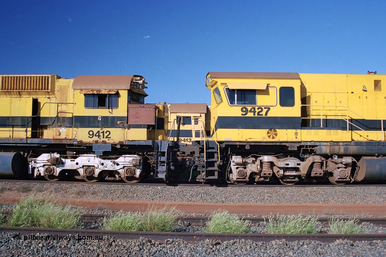 248-21
Seven Mile yard, stored Robe River ALCo locomotives at the south end of the Hamersley Iron Seven Mile yard on roads N2 and N3. On N2 is a cab comparison between AE Goodwin built ALCo M636 unit 9412 serial G-6060-3 from December 1971 and originally numbered 262.003 during construction and then 1712 on MLW Dofasco bogies with C636R units 9427 a Comeng WA C636R rebuild from ALCo Schenectady NY model C636 serial 3499-2 originally built in January 1968 for Pennsylvania Railroad as #6331, Penn Central 6331 and finally Conrail 6781. Purchased in 1986 and rebuilt by Comeng WA into C636R before delivery to Robe in January 1987 riding on the ALCo Hi-Ad bogie. This loco also went on to become DR 8403 for construction of FMG's railway in 2007-08. Behind it on N3 is 9413. Approximate [url=https://goo.gl/maps/CXwAreRPb2RymQ9m9]location[/url]. 24th April 2004.
Keywords: 9412;AE-Goodwin;ALCo;M636;G6060-3;