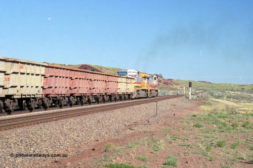 248-13
Dingo Siding on the Hamersley Iron railway at the 39 km with an empty train headed up by a pair of General Electric built Dash 9-44CW units 7077 serial 47756 from the original first order in the Pepsi Can livery and 9408 serial 54158 from the fourth order in the Pilbara Rail livery with Robe ownership markings powers away to the south with the signal marker boards are in the distance. Approximate [url=https://goo.gl/maps/Jv752bD5KXv28oUV7]location[/url]. April 24, 2004.
