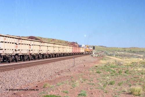 248-14
Dingo Siding on the Hamersley Iron railway at the 39 km with an empty train headed up by a pair of General Electric built Dash 9-44CW units 7077 serial 47756 from the original first order in the Pepsi Can livery and 9408 serial 54158 from the fourth order in the Pilbara Rail livery with Robe ownership markings powers away to the south back onto the mainline with the signal marker board DI19 for Dingo 19. Approximate [url=https://goo.gl/maps/Jv752bD5KXv28oUV7]location[/url]. April 24, 2004.
