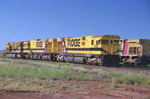 248-16
Seven Mile yard, stored Robe River ALCo locomotives at the south end of the Hamersley Iron Seven Mile yard on roads N2 and N3. On road N2 is 9426 a Comeng WA C636R rebuild from ALCo Schenectady NY model C636 serial 3499-3 originally built in January 1968 for Pennsylvania Railroad as #6332, Penn Central 6332 and finally Conrail 6782. Purchased in 1986 and rebuilt by Comeng WA into C636R before delivery to Robe in November 1986. This loco also went on to become DR 8401 for construction of FMG's railway in 2007-08. Behind it is sister unit 9427 and ALCo M636 9412. Approximate [url=https://goo.gl/maps/CXwAreRPb2RymQ9m9]location[/url]. April 24, 2004.
Keywords: 9426;Comeng-WA;C636R;WA143-1;rebuild;ALCo;Schenectady-NY;C636;Conrail;6782;3499-3;