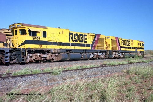 248-18
Seven Mile yard, stored Robe River ALCo locomotives at the south end of the Hamersley Iron Seven Mile yard on roads N2 and N3. On road N2 is 9427 a Comeng WA C636R rebuild from ALCo Schenectady NY model C636 serial 3499-2 originally built in January 1968 for Pennsylvania Railroad as #6331, Penn Central 6331 and finally Conrail 6781. Purchased in 1986 and rebuilt by Comeng WA into C636R before delivery to Robe in January 1987. This loco also went on to become DR 8403 for construction of FMG's railway in 2007-08. Behind it is sister unit 9426. Approximate [url=https://goo.gl/maps/CXwAreRPb2RymQ9m9]location[/url]. April 24, 2004.
Keywords: 9427;Comeng-WA;C636R;WA143-2;rebuild;ALCo;Schenectady-NY;C636;Conrail;6781;3499-2;