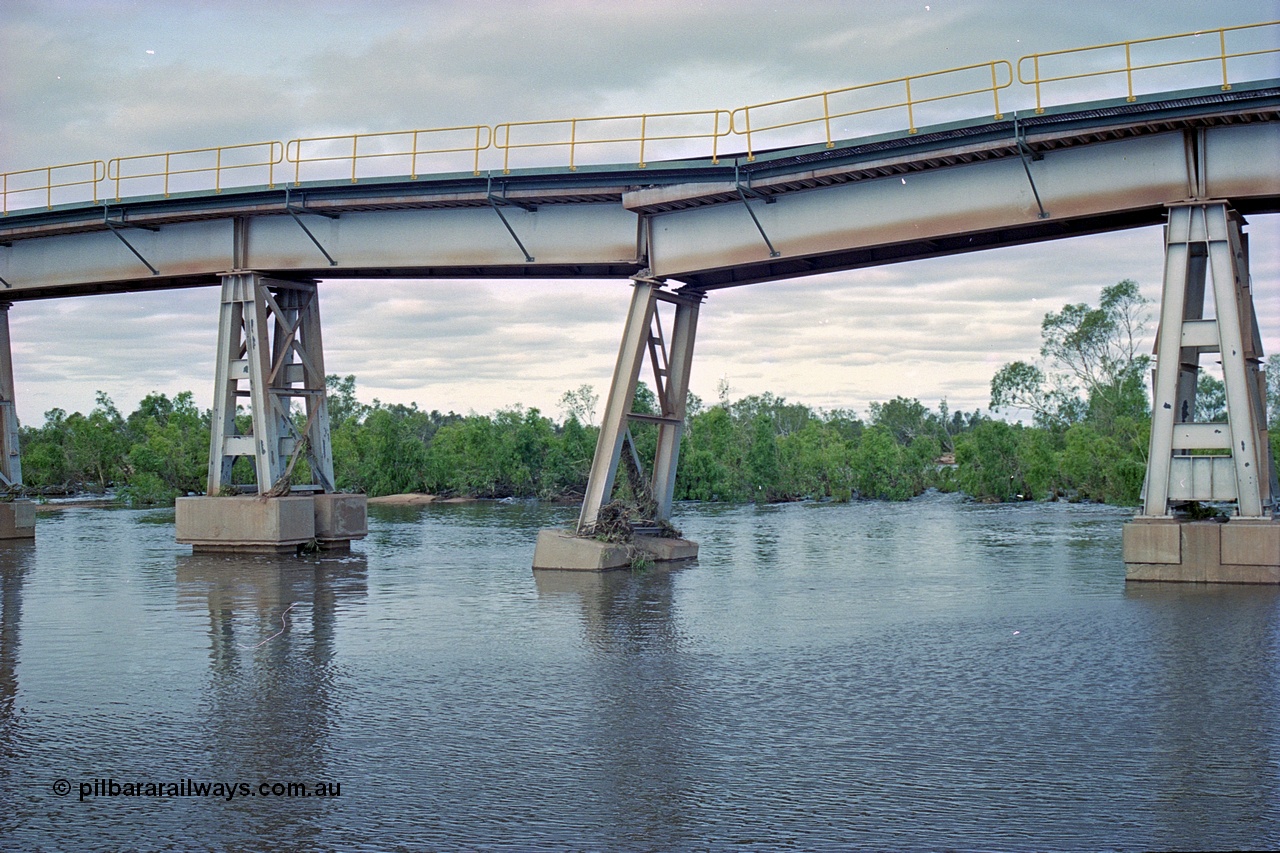 249-06
Yule River bridge looking east upstream the third pier from the southern end was undermined by flood waters from Tropical Cyclone John in December 1999. The rail line was closed for two weeks while repairs were effected. Approximate [url=https://goo.gl/maps/phCWr8u1xnuBdzwj6]location[/url].
