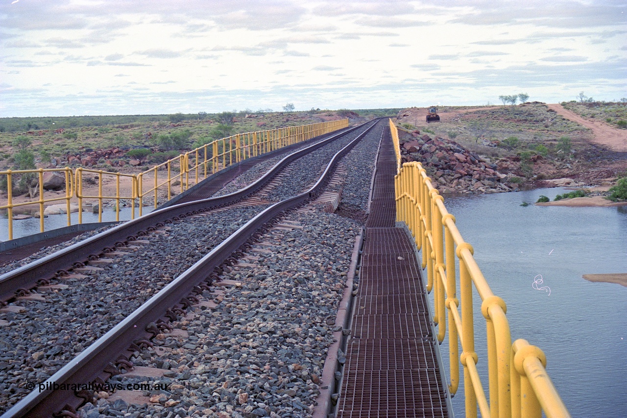 249-12
Yule River bridge looking north from the bridge deck on the BHP mainline of the sunk track section. The third pier from the southern end was undermined by flood waters from Tropical Cyclone John in December 1999. The rail line was closed for two weeks while repairs were effected. Approximate [url=https://goo.gl/maps/phCWr8u1xnuBdzwj6]location[/url].
