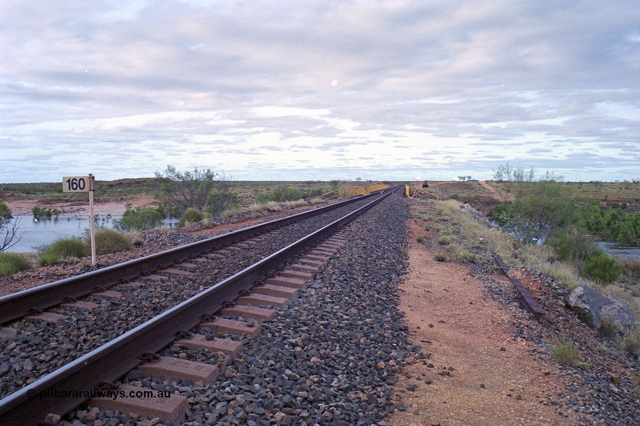 249-13
Yule River bridge looking north from the 160 km on the BHP mainline. The third pier from the southern end was undermined by flood waters from Tropical Cyclone John in December 1999. The rail line was closed for two weeks while repairs were effected. Approximate [url=https://goo.gl/maps/phCWr8u1xnuBdzwj6]location[/url].
