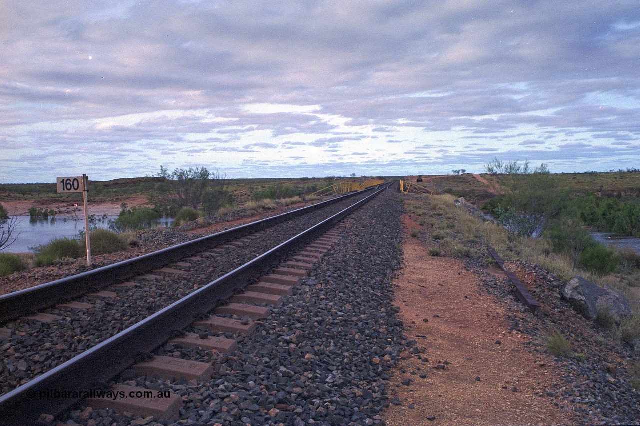 249-14
Yule River bridge looking north from the 160 km on the BHP mainline. The third pier from the southern end was undermined by flood waters from Tropical Cyclone John in December 1999. The rail line was closed for two weeks while repairs were effected. Approximate [url=https://goo.gl/maps/phCWr8u1xnuBdzwj6]location[/url].
