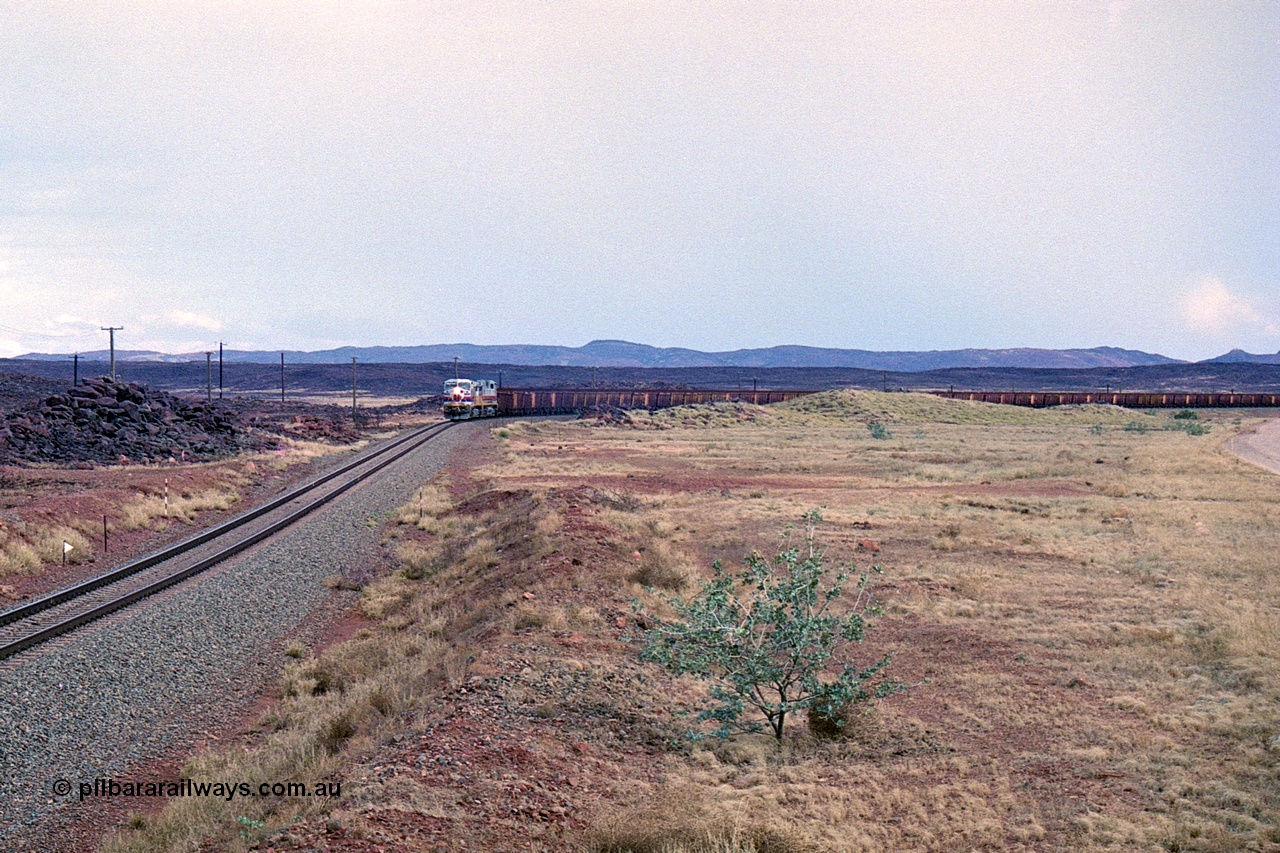 249-27
A loaded Hamersley Iron train runs across the plains north of Dugite Siding near the 70 km as it nears the destination of its cargo. Approximate [url=https://goo.gl/maps/UUfj15vTkvBaPCaw8]location[/url]. 18th December 1999.
