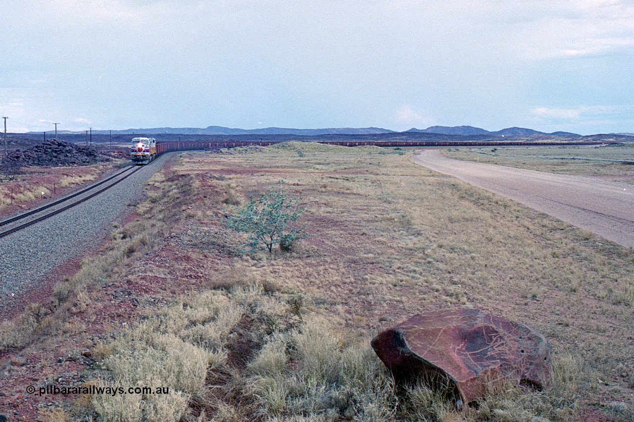 249-28
A loaded Hamersley Iron train runs across the plains north of Dugite Siding near the 70 km as it nears the destination of its cargo behind the standard pair of GE built Dash 9-44CW locomotives 7084 serial 47763 and 7079 serial 47758 both in the original Pepsi Can livery. Approximate [url=https://goo.gl/maps/UUfj15vTkvBaPCaw8]location[/url]. 18th December 1999.
Keywords: 7084;GE;Dash-9-44CW;47763;