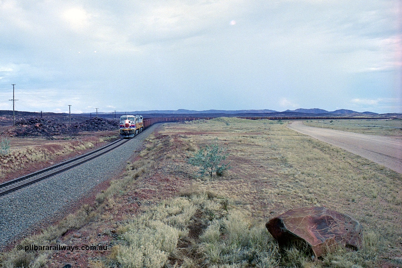 249-29
A loaded Hamersley Iron train runs across the plains north of Dugite Siding near the 70 km as it nears the destination of its cargo behind the standard pair of GE built Dash 9-44CW locomotives 7084 serial 47763 and 7079 serial 47758 both in the original Pepsi Can livery. Approximate [url=https://goo.gl/maps/UUfj15vTkvBaPCaw8]location[/url]. 18th December 1999.
Keywords: 7084;GE;Dash-9-44CW;47763;