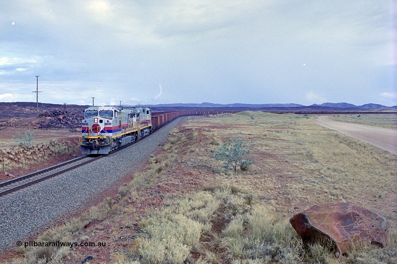 249-30
A loaded Hamersley Iron train runs across the plains north of Dugite Siding near the 70 km as it nears the destination of its cargo behind the standard pair of GE built Dash 9-44CW locomotives 7084 serial 47763 and 7079 serial 47758 both in the original Pepsi Can livery. Approximate [url=https://goo.gl/maps/UUfj15vTkvBaPCaw8]location[/url]. 18th December 1999.
Keywords: 7084;GE;Dash-9-44CW;47763;