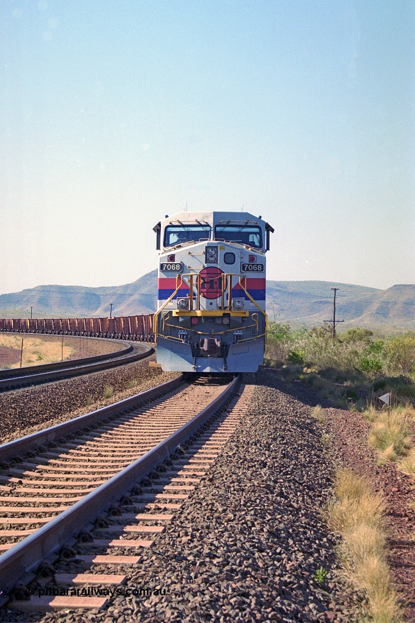 250-01
Pelican Siding on the Hamersley Iron Tom Price line about the 208 km with an empty train behind the standard pairing of two General Electric built 9-44CW units 7068 serial 47747 and 7067 serial 47746 stand on the loop or passing track for a meet with a loaded train. 21st October 2000.
Keywords: 7068;GE;Dash-9-44CW;47747;