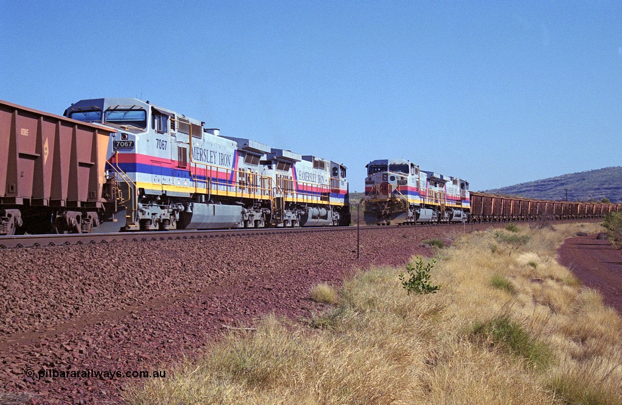 250-11
Pelican Siding on the Hamersley Iron Tom Price line about the 208 km with an empty train behind General Electric built 9-44CW units 7068 serial 47747 and 7067 serial 47746 on the loop as a loaded train with 210 waggons passes behind a sister pairing of 7072 serial 47751 and 7074 serial 47753. 1550 hrs 21st October 2000.
Keywords: 7072;GE;Dash-9-44CW;47751;