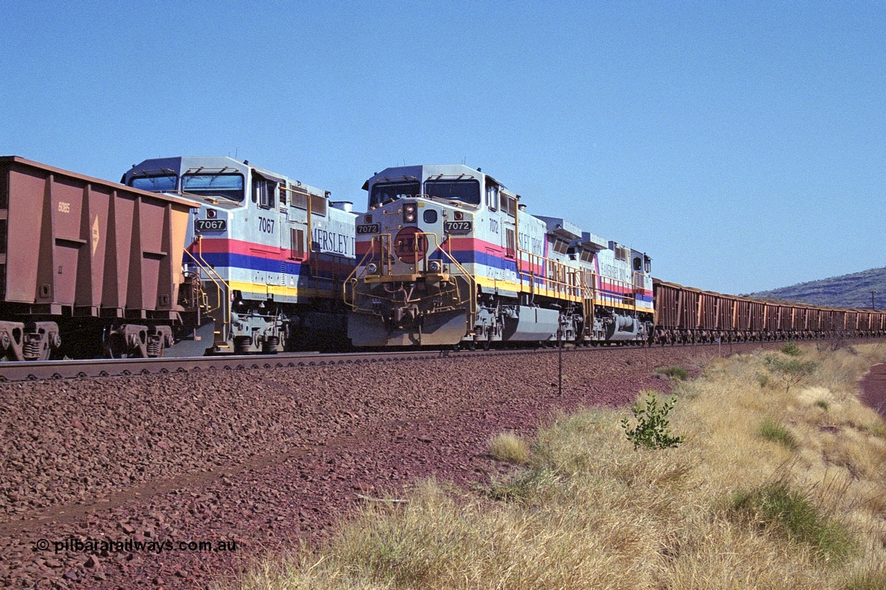 250-12
Pelican Siding on the Hamersley Iron Tom Price line about the 208 km with an empty train behind General Electric built 9-44CW units 7068 serial 47747 and 7067 serial 47746 on the loop as a loaded train with 210 waggons passes behind a sister pairing of 7072 serial 47751 and 7074 serial 47753. 1550 hrs 21st October 2000.
Keywords: 7072;GE;Dash-9-44CW;47751;